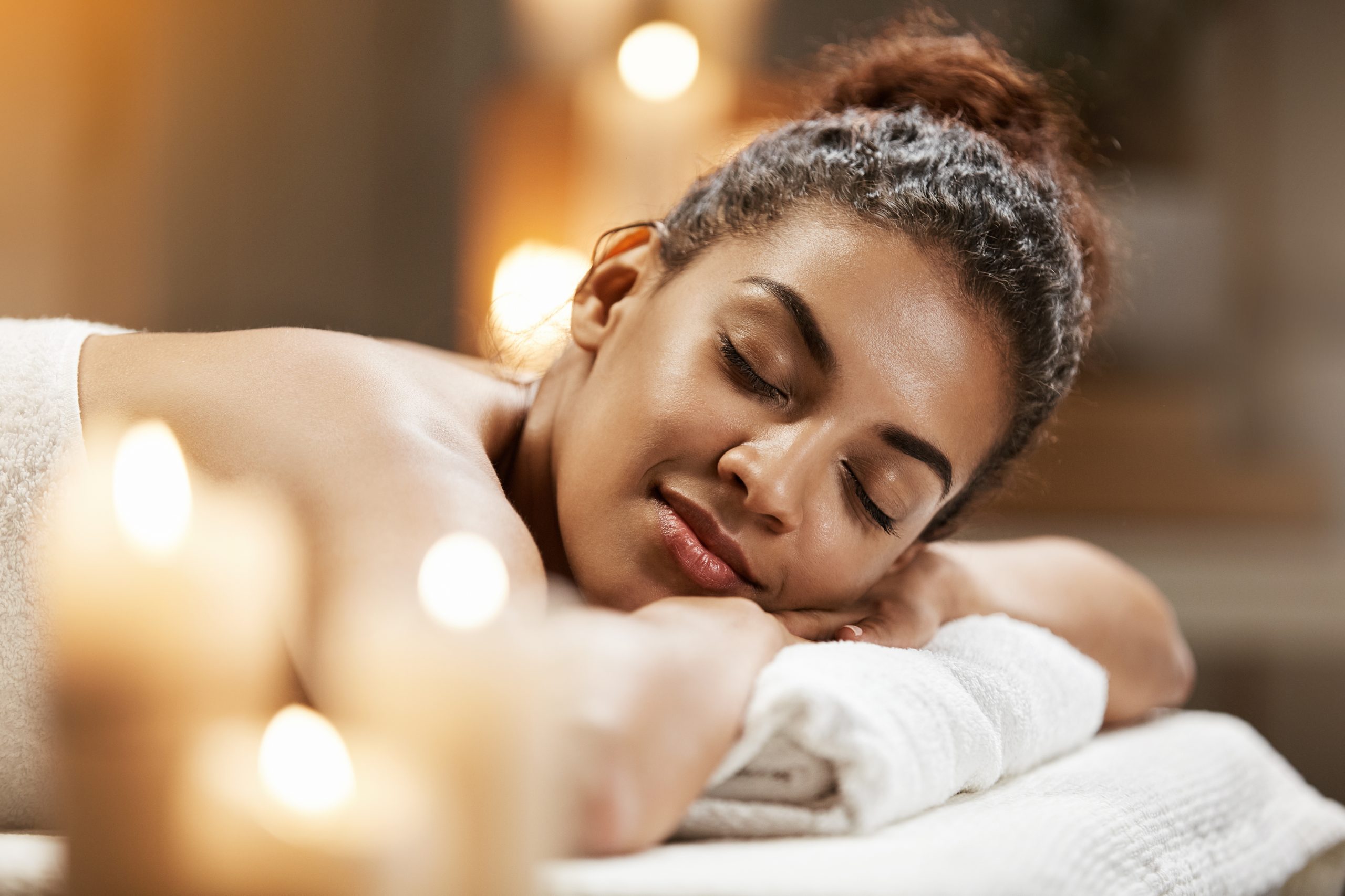 Beautiful african girl resting relaxing in spa resort with closed eyes.